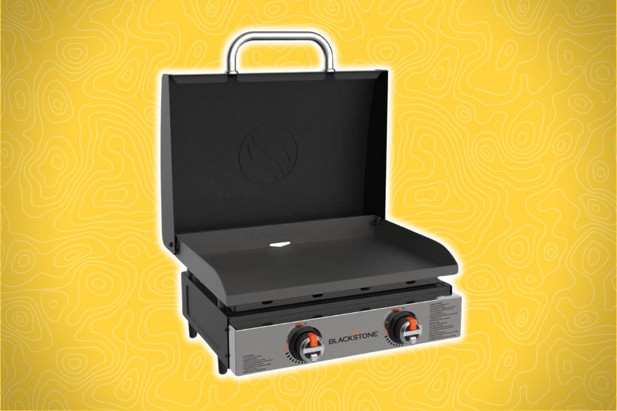 A portable propane griddle with two control knobs and an open lid, set against a yellow background with abstract line patterns.