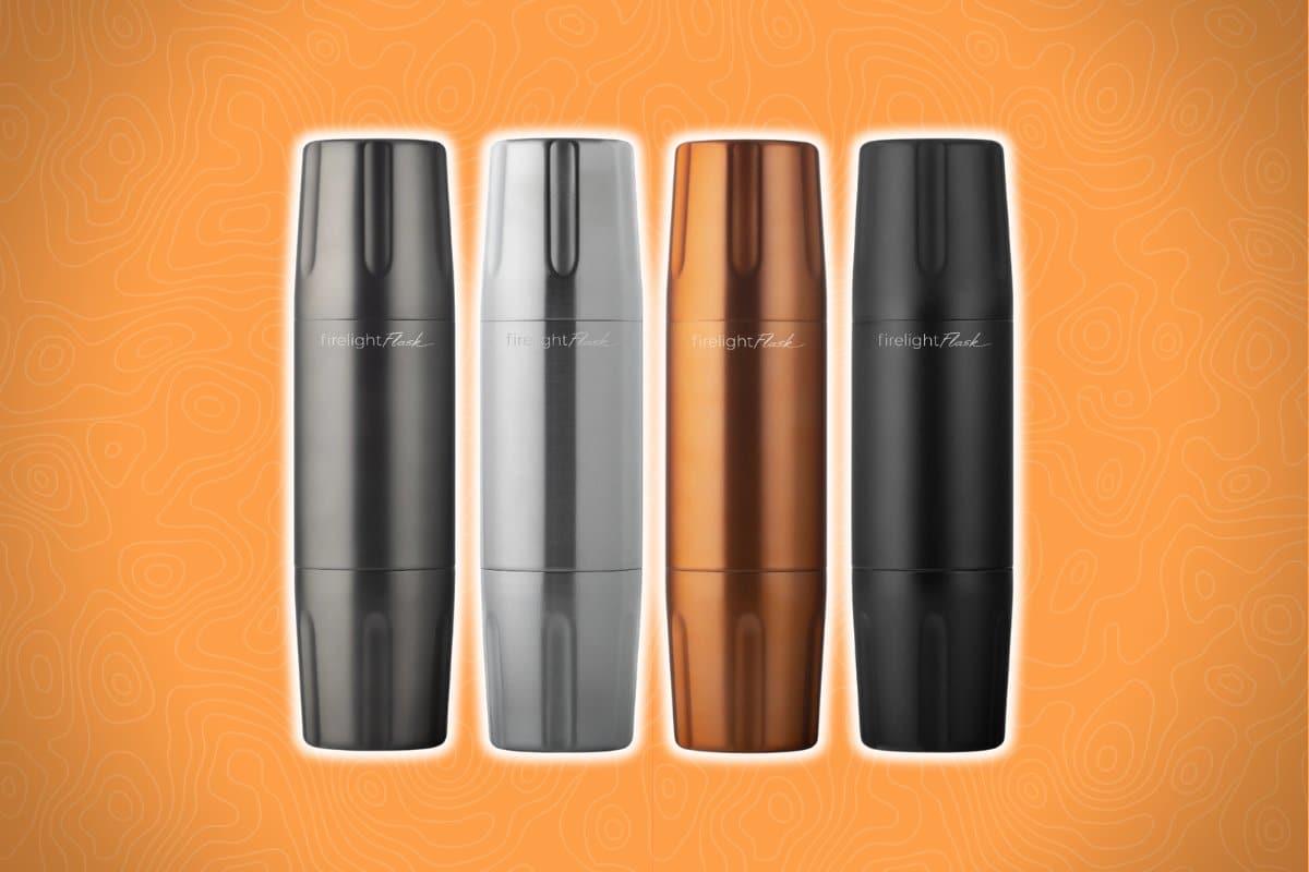 Four sleek, cylindrical stainless steel flasks in silver, dark silver, copper, and black are lined up against an orange background with a subtle abstract pattern.